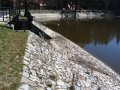 Hráz Konopišťského rybníka opevněná kamennou rovnaninou