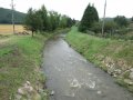 Koryto vodního toku Třebůvka za silničním mostem (III/37332) po toku